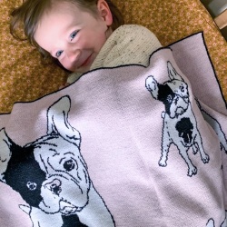 Girl wrapped under a Branberry Australian made knitted merino wool French bulldog (frenchie) blanket in Pale Pink